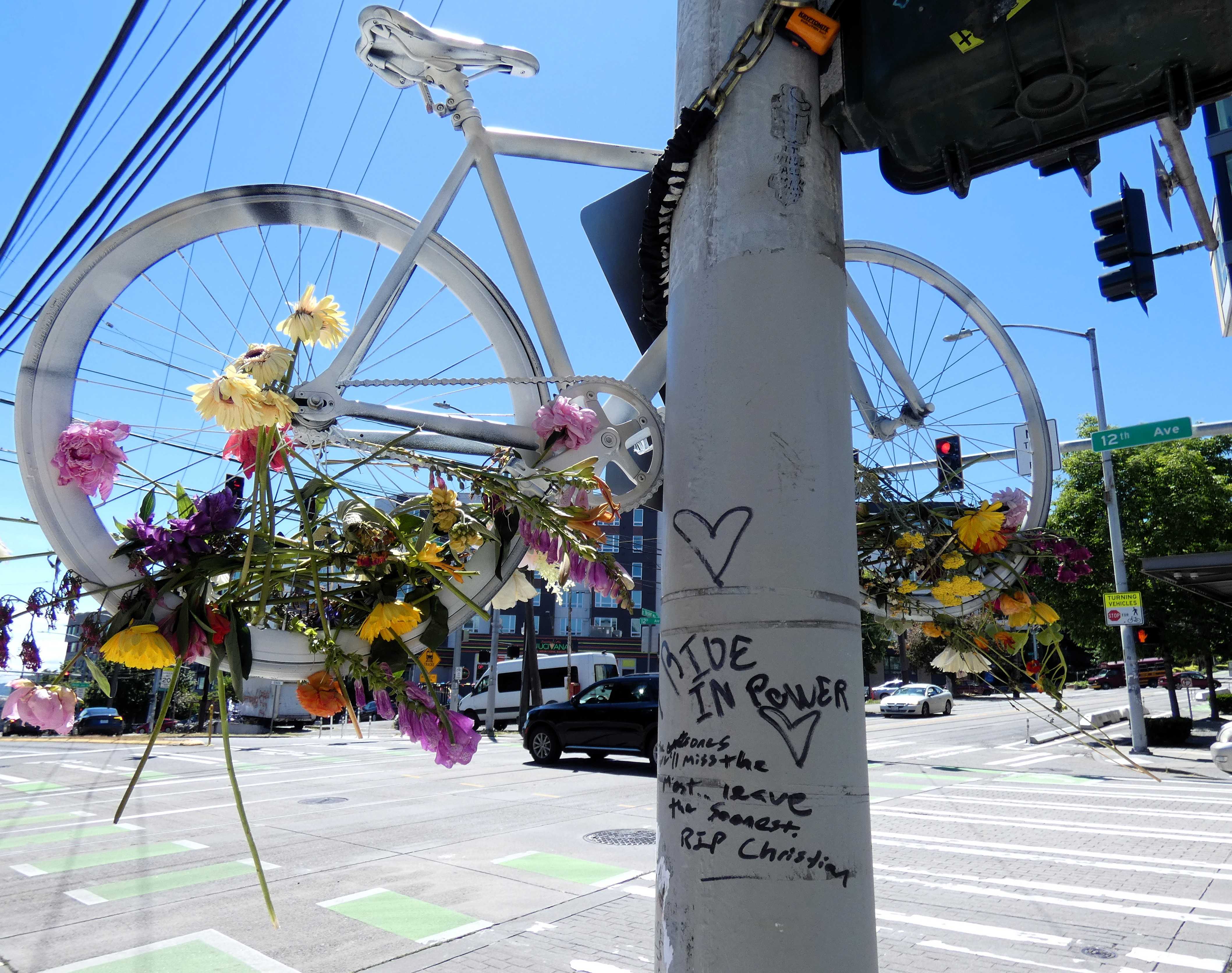 Messages on the utility pole where a ghost bike is mounted