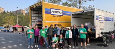 Volunteers post in front of event trucks.