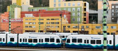 Sound Transit light rail trains in front of some buildings