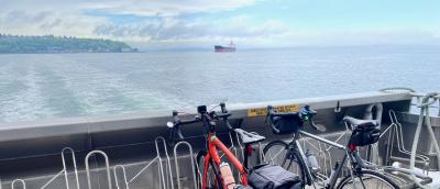 2 bicycles sit on the bike racks at the rear of the West Seattle Water Taxi as it cruises across Elliott Bay from West Seattle towards the Seattle Waterfront