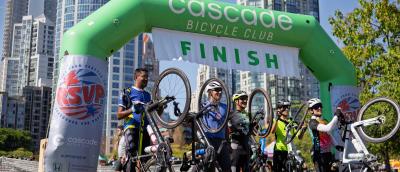 A group of riders celebrate at the Vancouver, BC finish line in 2025.