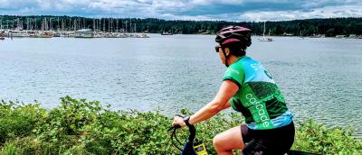 A woman rides her e-bike on the Kitsap Color Classic