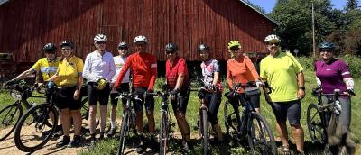 Sunny day with cyclists in front of red barn