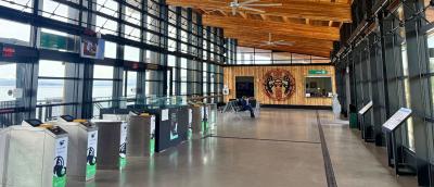 interior of the Mukilteo Ferry Terminal in the shape of a cedar longhouse with wooden ceiling, new kiosks, windows on the sides, and tribal artwork