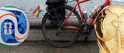 image of a FIFA World Cup soccer ball on the left, the rear wheel of a road bicycle in middle, and the spherical portion of the World Cup trophy on the right