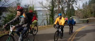 Smiling riders climbing a seaside hill on Chilly Hilly