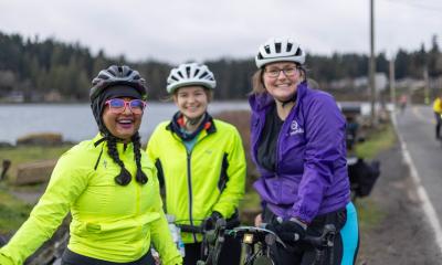 Three riders gather near the water for a quick photo.