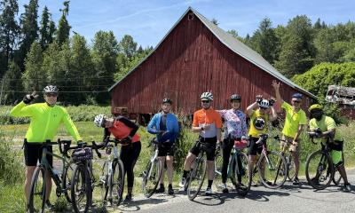 Goofy cyclists in front of red barn