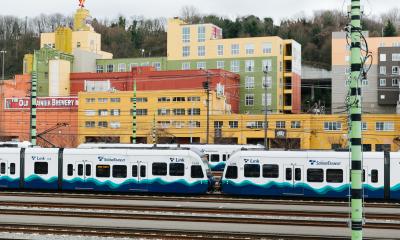 Sound Transit light rail trains in front of some buildings