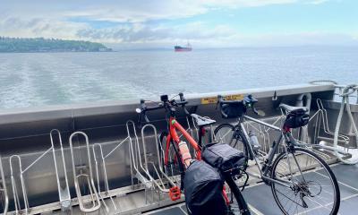 2 bicycles sit on the bike racks at the rear of the West Seattle Water Taxi as it cruises across Elliott Bay from West Seattle towards the Seattle Waterfront