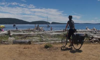 Photo by Earth Wandering, public via Flickr. Person bike touring on the San Juan Islands in 2018.