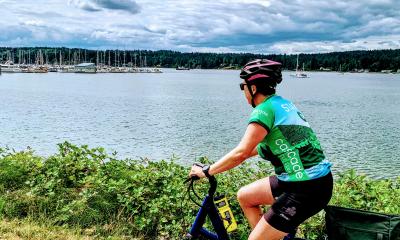 A woman rides her e-bike on the Kitsap Color Classic