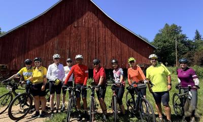 Sunny day with cyclists in front of red barn