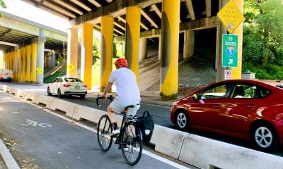Concrete barriers separate cars from people biking on Ravenna Avenue