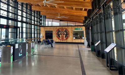 interior of the Mukilteo Ferry Terminal in the shape of a cedar longhouse with wooden ceiling, new kiosks, windows on the sides, and tribal artwork