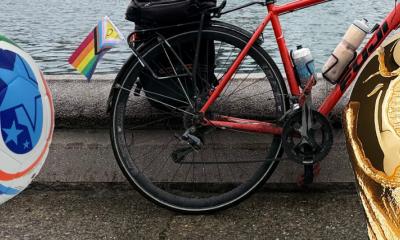 image of a FIFA World Cup soccer ball on the left, the rear wheel of a road bicycle in middle, and the spherical portion of the World Cup trophy on the right