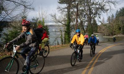 Smiling riders climbing a seaside hill on Chilly Hilly