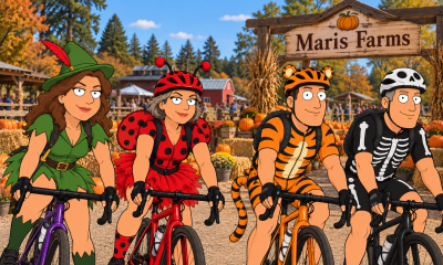 Cartoon of four cyclists in Halloween costumes—Peter Pan, ladybug, tiger, and skeleton—riding past Maris Farms pumpkin patch.